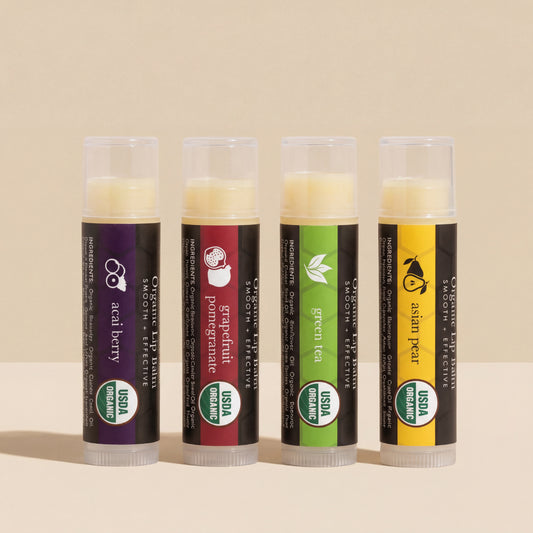 Four organic lip balm tubes with different flavors on a beige background