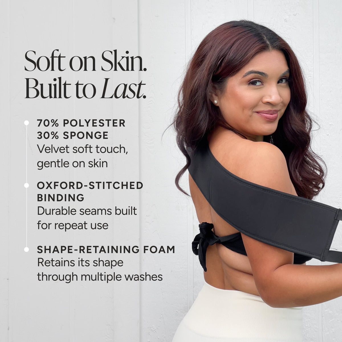 A woman using a back applicator is shown from the back against a light gray wall, with marketing text on the left describing the product's materials and features.