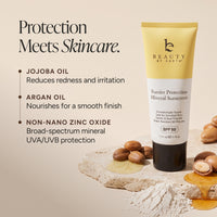 Beauty by Earth Barrier Protection Mineral Sunscreen SPF 50 in a yellow and white squeeze tube, displayed on a beige background with jojoba oil, argan nuts, and powder.