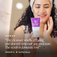 A woman in a bathroom setting holds up a purple and white tube of Beauty by Earth Cleansing Face Scrub. The image includes a five-star rating graphic and a customer testimonial quote from Maggie S.