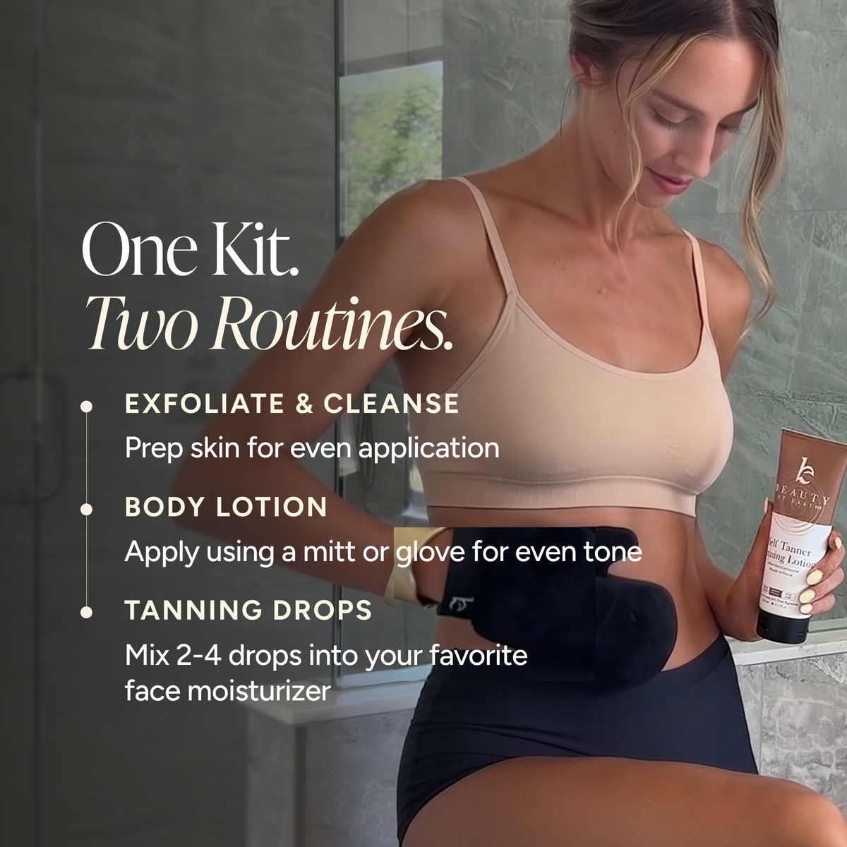 A woman in a beige sports bra and black shorts stands in a bathroom holding a tanner bottle.