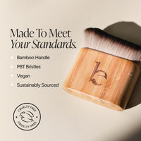 A bamboo-handled  brush with soft bristles, shown on a warm beige background with marketing text highlighting bamboo handle, PBT bristles, vegan formula, and sustainably sourced materials. A circular cruelty-free logo appears in the lower left.