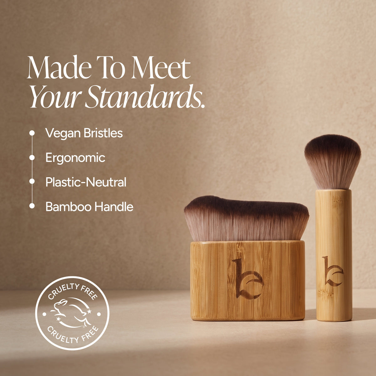 Two bamboo brushes with dark brown bristles are displayed on a beige surface against a textured beige background. One brush is shown in a square bamboo case and the other is upright.
