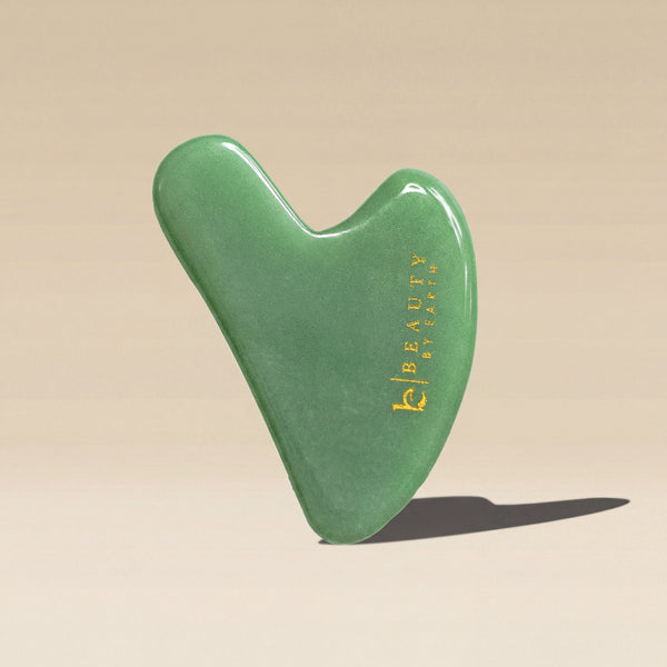 Green jade gua sha tool with 'Beauty by Earth' 