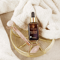 Beautycounter face oil bottle with roller and stones on a textured surface
