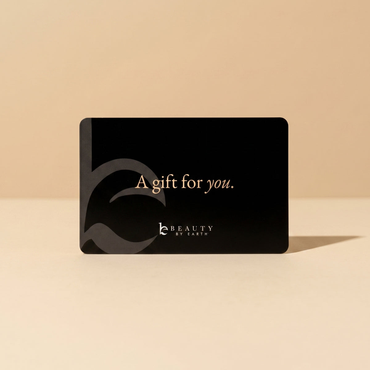 Black gift card with 'A gift for you.' text on a beige background