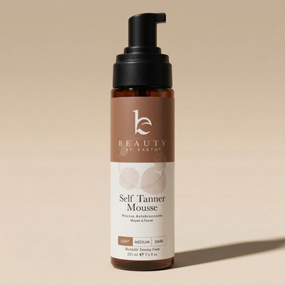Bottle of 'Self Tanner Mousse' by Beauty by Earth on a beige background