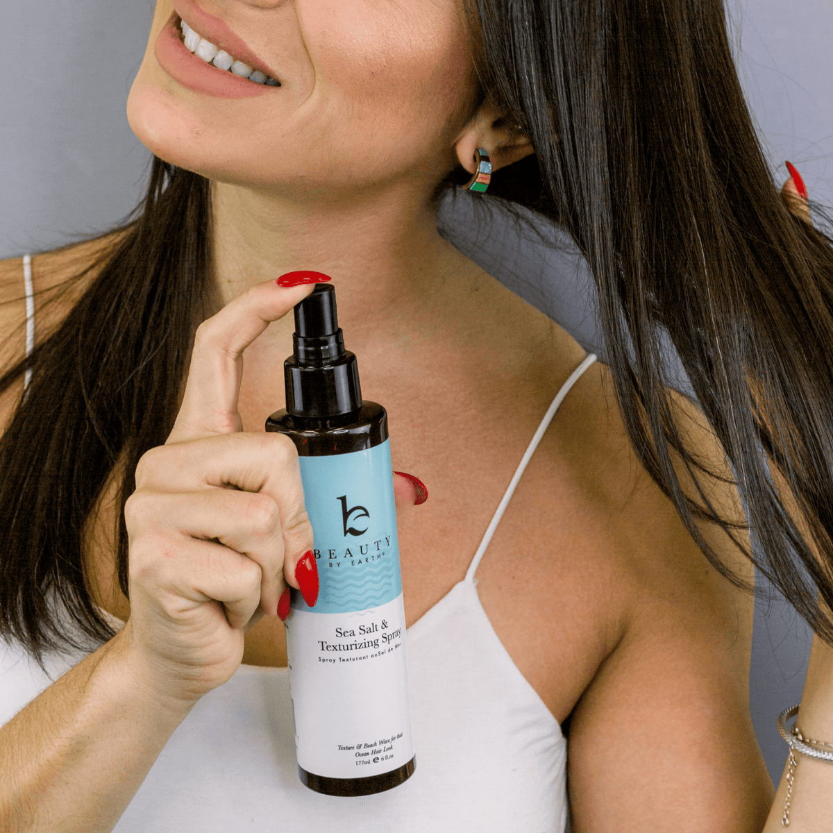 Woman with Sea Salt Spray Hair Texturizer, suitable for clean beauty routines and natural hair care