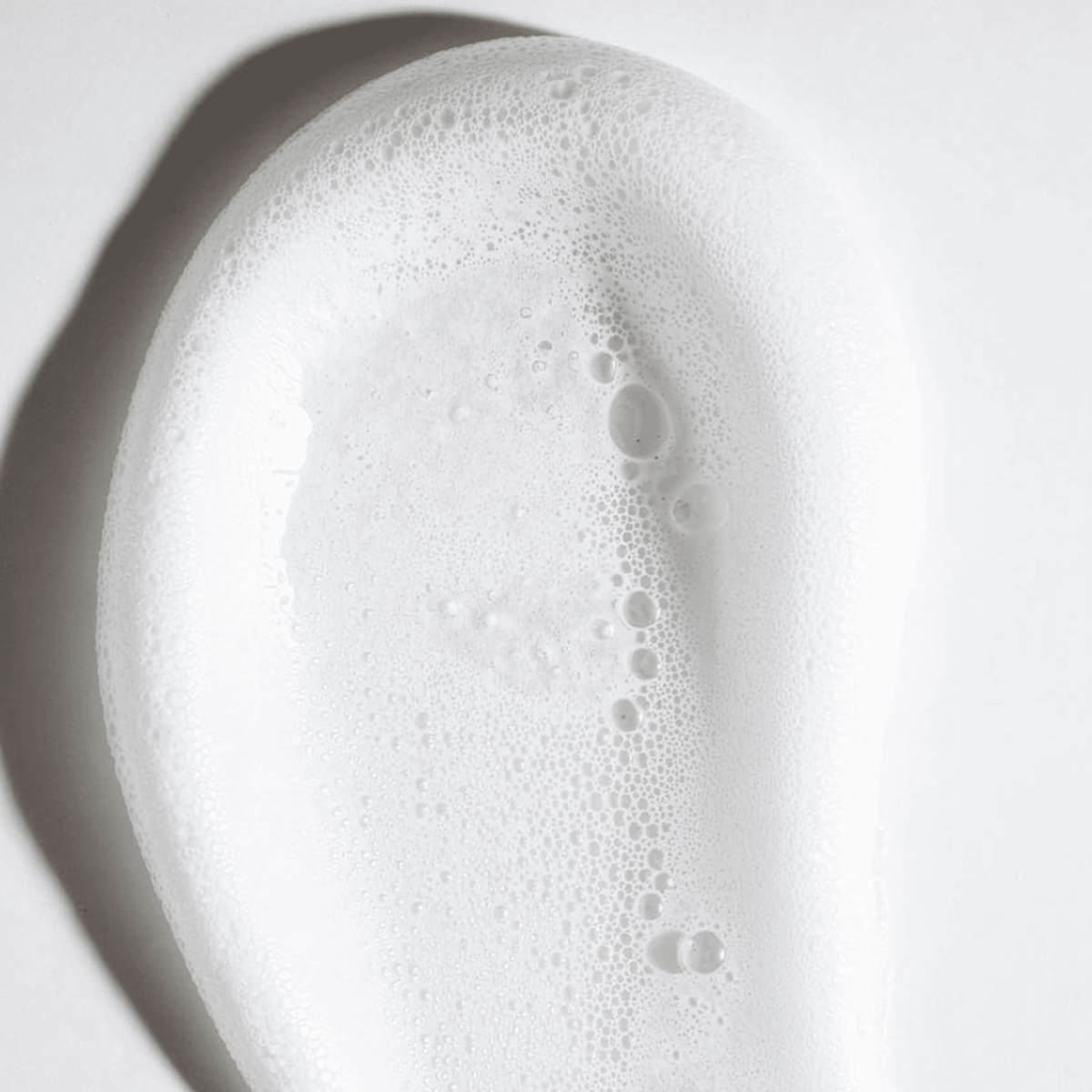 Macro texture of self tanning mousse on white background.
