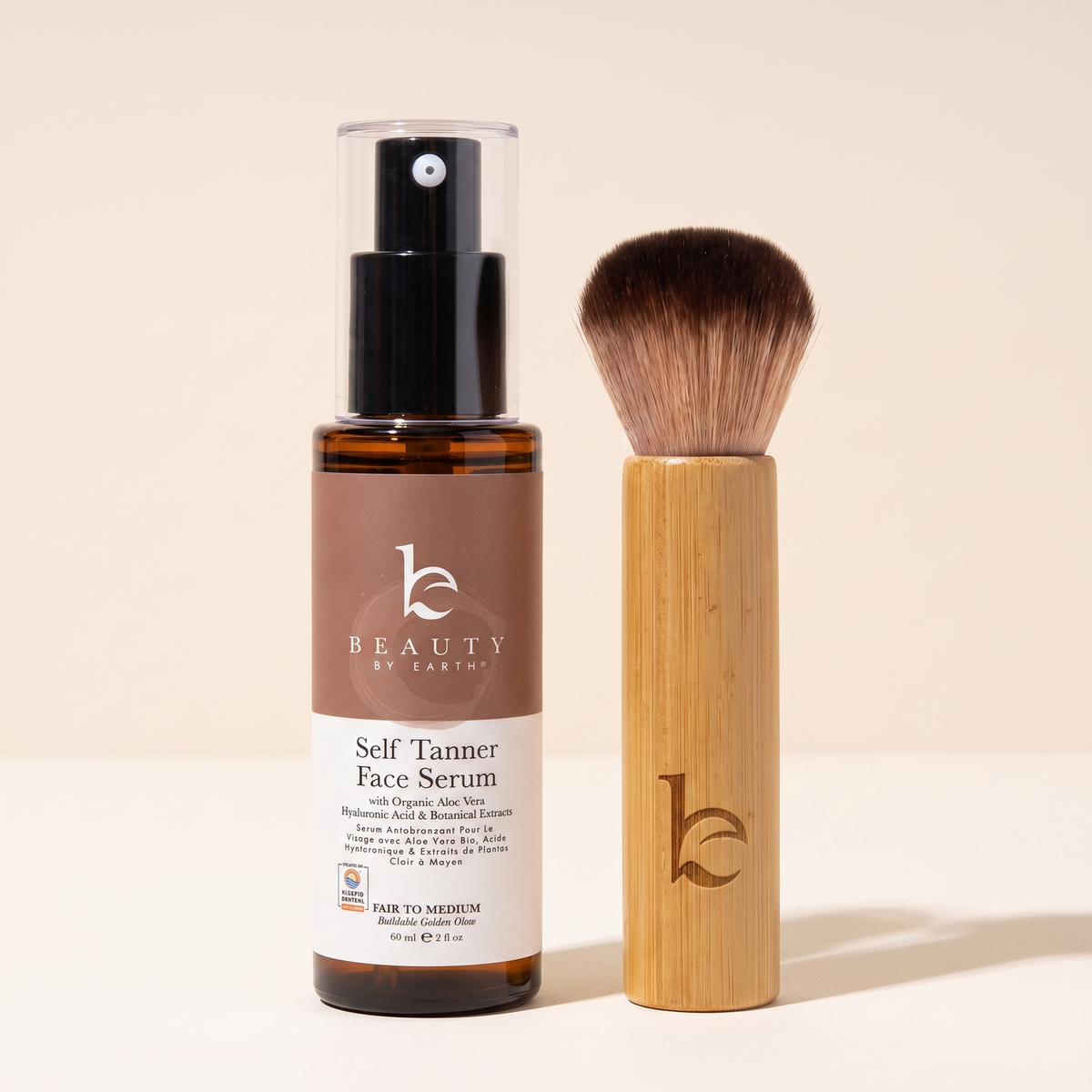 Self Tanner face serum fair to medium with a kabuki facial brush on a light gray background