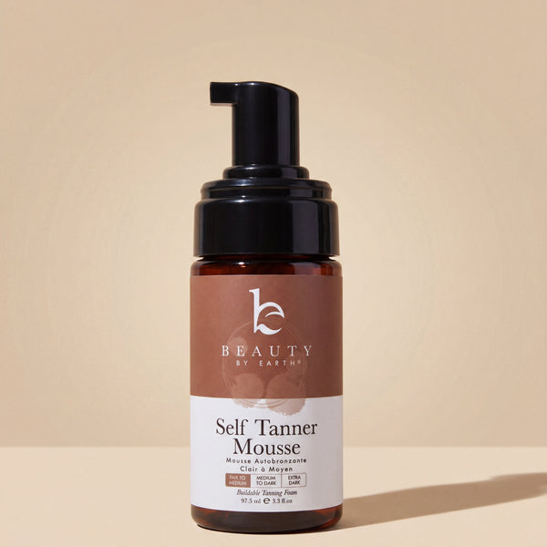 Beauty by Earth Self Tanner Mousse bottle on a beige background