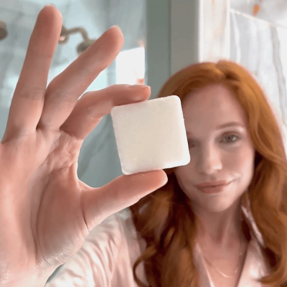 Women holding a single Shower steamer cube in hand before using it.