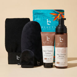 Beauty by Earth self tanning mousse and face lotion fair to medium bundle with application kit black body and face mitt, and exfoliation glove on a beige background.