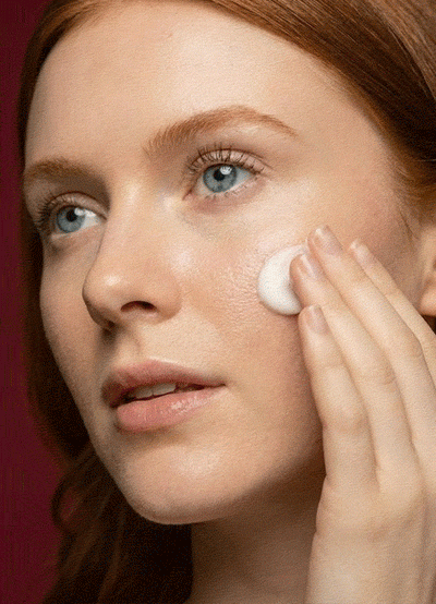 woman applying facial moisturizer